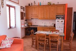 une cuisine avec une table et des chaises et une cuisine avec des placards en bois dans l'établissement Il Pesce e il Geco, à Lipari