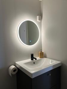 a bathroom with a white sink and a mirror at Studioapartment in city centrum in Tromsø +2 photos