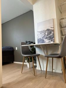 a desk and two chairs in a room at Studioapartment in city centrum in Tromsø