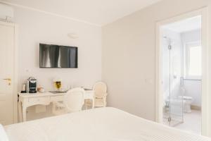 a white bedroom with a desk and a bed at VILLA AGA in Noli