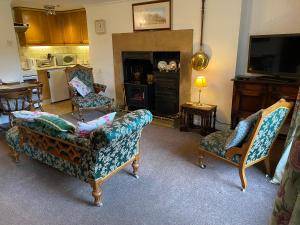 a living room with a couch and two chairs and a fireplace at Bellfield Country Suites in Masham