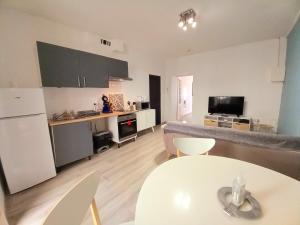 cocina pequeña y sala de estar con mesa blanca en TERRASSE du GET, en Revel