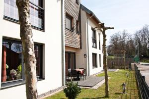 a white house with a patio and a yard at Appartements La Maison du Tigre in Stutzheim