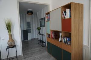 um quarto com uma estante de livros com livros em Un trois étoiles entre La Rochelle et les marais poitevin em Marans