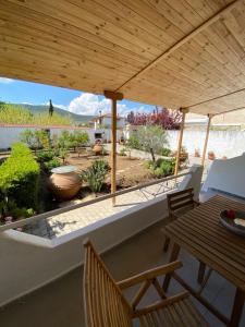 a porch with a wooden pergola and a table and chairs at Δωματια ΞΑΝΘΟΥΛΑ in Amaliapoli