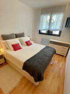 una camera da letto con un grande letto con cuscini rossi di Talipas a Les Bons