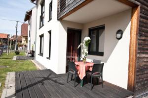 a wooden deck with a table and chairs on a house at Appart'hôtels La Maison du Tigre in Stutzheim