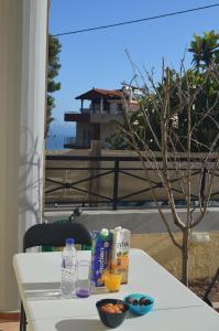 a white table with food and drinks on a balcony at Not a Villa in Roussospítion