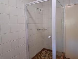 a shower with a glass door in a bathroom at Remhoogte Mountain Lodge in Jacksonstuin