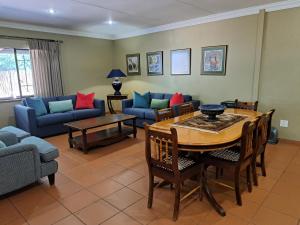 a living room with a table and a couch at Remhoogte Mountain Lodge in Jacksonstuin