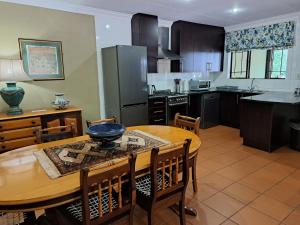 a kitchen with a wooden table and a dining room at Remhoogte Mountain Lodge in Jacksonstuin