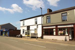 a white building on the side of a street at Cosy 1Bed Apartment in Heywood with Free Parking in Heywood