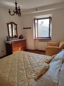 a bedroom with a large bed and a dresser and a window at Casa Vittoria in Verni