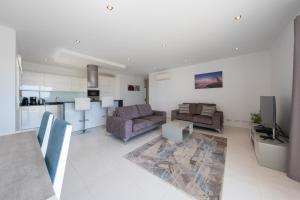 sala de estar con 2 sofás y cocina en Porto de Mós 72 by Destination Algarve, en Lagos