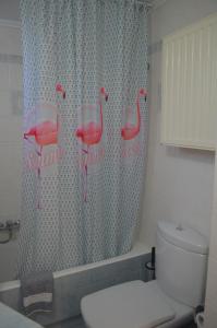 a bathroom with a shower curtain with flamingos on it at Not a Villa in Roussospítion