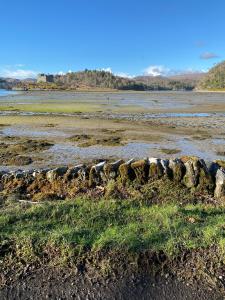 a rock wall on the shore of a body of water at Brackenbrae Holiday Cottage in Acharacle
