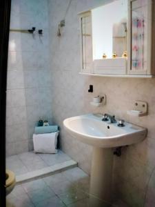 La salle de bains blanche est pourvue d'un lavabo et d'une douche. dans l'établissement RENT ROOM JOE Via Dante 77 Solarino, à Solarino