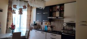 a kitchen with black cabinets and a table and a window at Azzurra holiday home - 850 m al mare - 75 mq - balconata vivibile - wi-fi - pay tv gratis - posteggio auto condominiale non assegnato in Rapallo