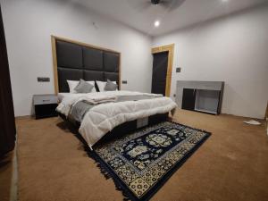 a large bedroom with a large bed and a rug at Natures View Residency in Hundar