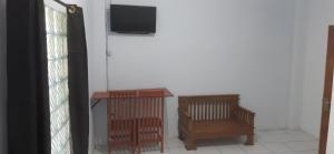 a room with a television and a table and chairs at Lejo Grand Hotel in Cikembulan