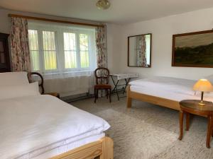 a bedroom with two beds and a table and a chair at Wohnung mit Garten, Grill und Thermomix in Ühlingen-Birkendorf