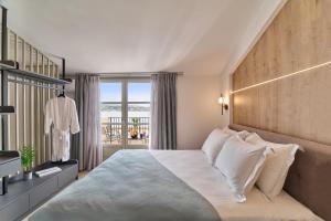 1 dormitorio con 1 cama grande y balcón en PORTA SQUERO Premium Suites en Rethymno