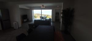 sala de estar con sofá y ventana grande en F4 à Porticcio avec piscine et vue sur mer en Porticcio