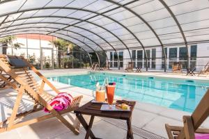 a pool with a table and a chair next to a pool at Westotel Tours Val de Loire in La Ville-aux-Dames +96 photos