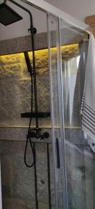 una puerta de ducha de cristal con una manguera colgando de ella en Ático Almuiña. en Marín