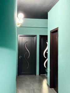 a hallway with three doors with a snake on them at GS Hotel in Tbilisi City