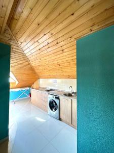 a kitchen with a washing machine and a wooden ceiling at GS Hotel in Tbilisi City