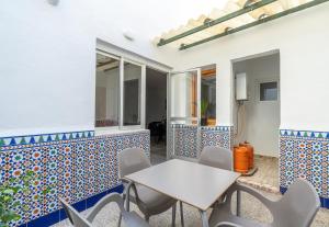 una mesa y sillas en un patio con azulejos azules y blancos en Casa Granada budget Haus bei Granada, en Dúrcal