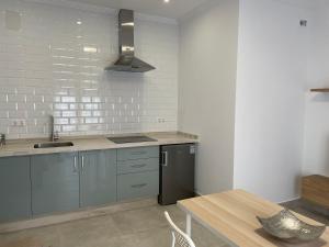 a kitchen with blue cabinets and a sink and a table at Casa Yate in Isla del Moral