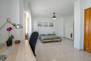 1 dormitorio con 1 cama y 1 mesa en una habitación en Casa Granada budget Haus bei Granada, en Dúrcal