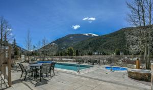 eine Terrasse mit einem Tisch, Stühlen und einem Pool in der Unterkunft Red Hawk Lodge 2297 in Keystone