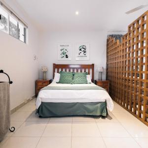 1 dormitorio con 1 cama grande en una habitación en Poolside Cottage en Johannesburgo