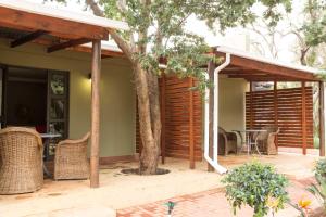 a house with a patio with a table and chairs at Remhoogte Mountain Lodge in Jacksonstuin
