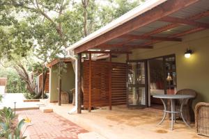 a patio with a wooden pergola and a table at Remhoogte Mountain Lodge in Jacksonstuin