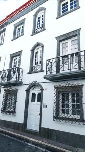 un edificio blanco con una puerta y ventanas blancas en Colégio 86 en Ponta Delgada