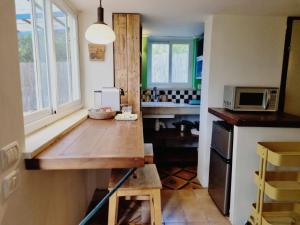 a kitchen with a wooden table and a microwave at יחידת אירוח נעם in Netiv HaLamed He