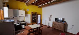 a kitchen with a table and a kitchen with yellow walls at Casa di Company in Greve in Chianti