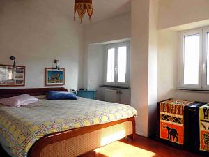 um quarto com uma cama e duas janelas em @gatetothewild em Coreglia Ligure