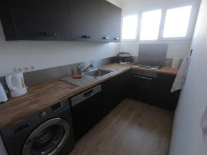 a kitchen with a washing machine and a sink at Appartement Bordeaux meublé tourisme classé 3 étoiles in Bruges