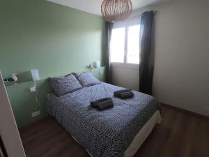 a bedroom with a bed with two bags on it at Appartement Bordeaux meublé tourisme classé 3 étoiles in Bruges