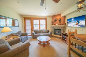 uma sala de estar com um sofá, uma mesa e uma televisão em Red Hawk Townhomes 2352 em Keystone