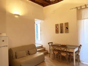 - un salon avec une table et un canapé dans l'établissement Julie - Graziosa casa del '700, à Castel Gandolfo