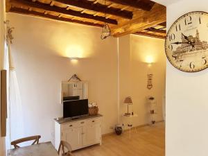 un salon avec une horloge murale et une table dans l'établissement Julie - Graziosa casa del '700, à Castel Gandolfo