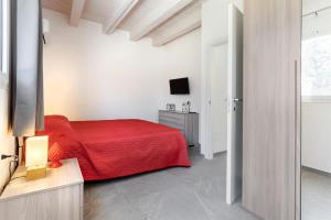 a bedroom with a red bed and a television at Amurusu Residence in Punta Secca