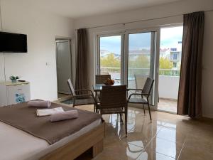 a bedroom with a bed and a table and chairs at CekajPlace in Ulcinj