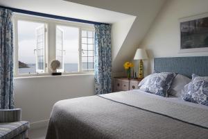 a bedroom with a bed and a large window at Hotel Tresanton in Saint Mawes
